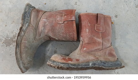 Dirty Shoes Of A Concrete Construction Worker. Already Through A Tough Job