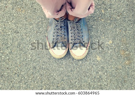 The dirty  shoes standing on the road in vintage style concept of adventure 