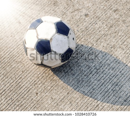 Dirty soccer ball isolated on concrete road