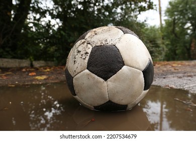 Dirty Soccer Ball In Muddy Puddle, Closeup