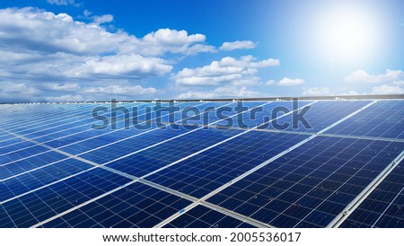 Dirty solar cell panels installed on the roof top of a house with white clouds ,blue sky and the sunlight, to provide power to the house, to go green energy concept