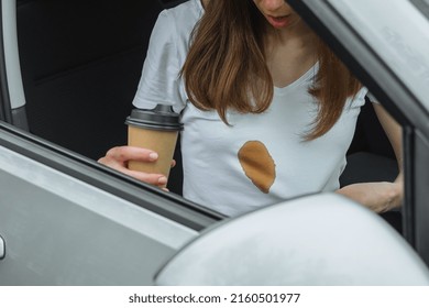 Dirty Stain Of Spilled Coffee While Driving. Woman Showing A Stain On White Clothes. Daily Life Stain Concept. High Quality Photo