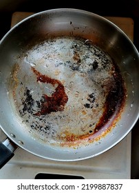 Dirty Stainless Steel Fry Pan.  Beat Up And Has Burnt Scars Sitting In The Sink