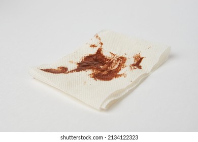 Dirty Toilet Paper Sheet On White Background With Copy Space. Peace Of Toilet Paper With Chocolate Butter, Close-up