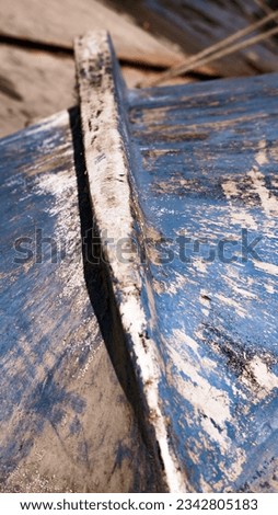 The dirty underside of an old blue boat.