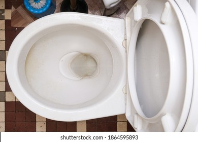 Dirty unhygienic toilet bowl with limescale stain at public restroom, top view.