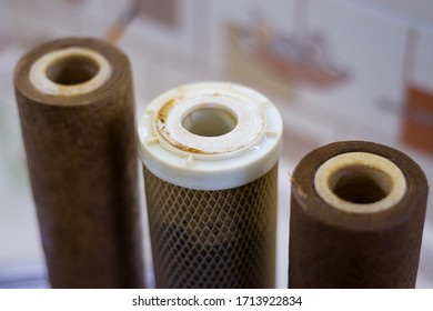 Dirty used reverse osmosis system cartridges on a kitchen background. Elements of a filtration system for clean and healthy water.