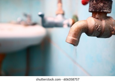 
The Dirty Water Faucet Is Dripping In Bathroom With Strong Light 