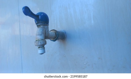 Dirty Water Faucet, Serves To Regulate The Discharge Of Clean Water, With A White Color And A Blue Handle, Visible From The Side.