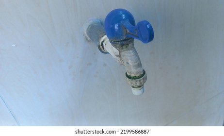 Dirty Water Faucet, Serves To Regulate The Discharge Of Clean Water, With A White Color And A Blue Handle, Seen From Above.