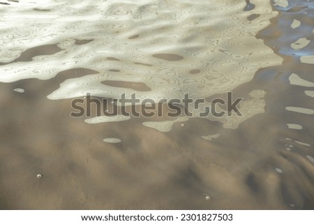 Dirty water. Puddle texture. Cloudy liquid. Waves on surface.
