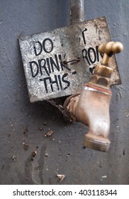 Dirty water tap, with a warning not to drink the water. Water is unsafe for consumption.