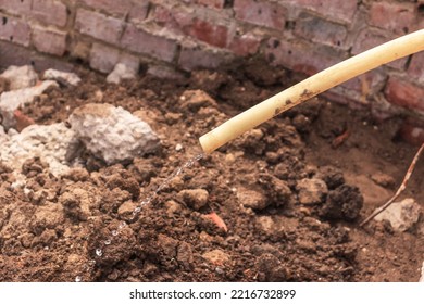 Dirty Water In A Thin Stream Flowing Out Of A Dirty Pipe Against The Background Of Dirt