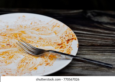 Dirty White Dish And Fork With Pasta Sauce 