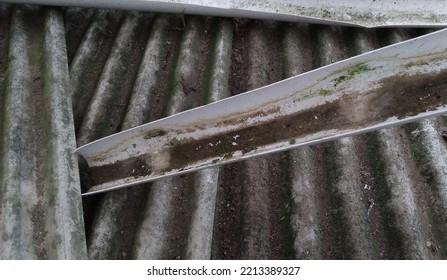 Dirty White PVC Pipe Split On The  Dirty Asbestos Sheets.