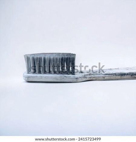 a dirty white toothbrush, with a white background