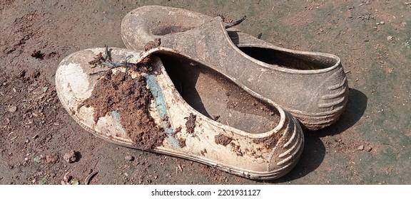 Dirty Work Boots Full Of Silt Are Lying Next To The House