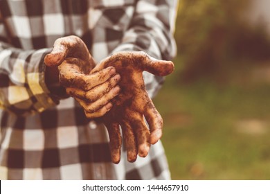 Dirty Working Farmer Hands In Soil Standing In Garden