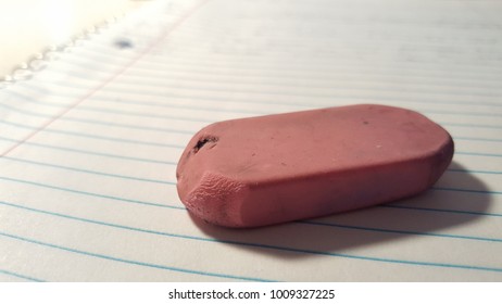 Dirty Worn Pink Rubber Eraser On Lined Spiral Notebook Page