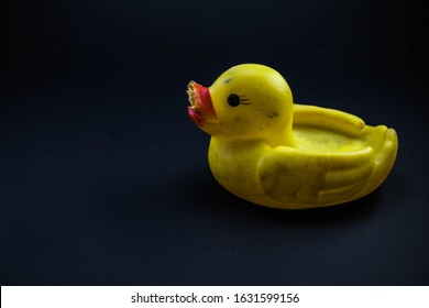 Dirty Yellow Rubber Duck With Damaged Beak Isolated On Dark Blue Background, Space For Text.