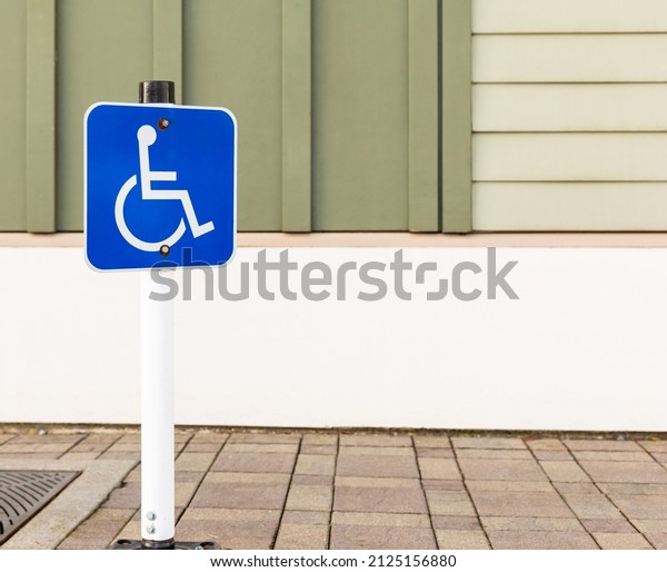 Disability car parking sign to reserved\
space for handicap driver vehicle park. Road sign for disabled\
parking. Street photo, nobody, copy space for\
text