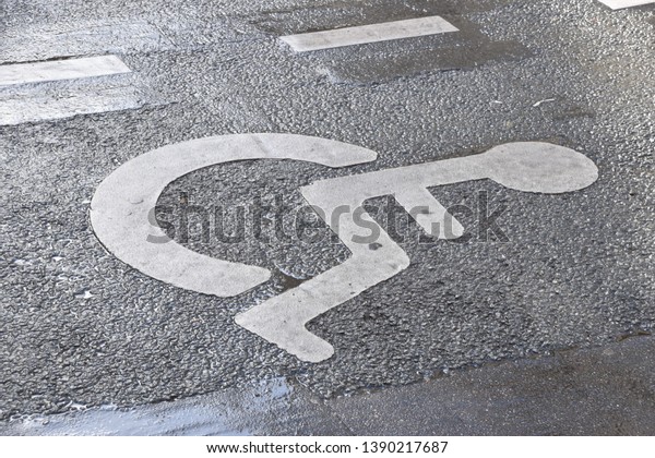 Disability icon painted\
on the asphalt to restrict parking for handicapped people only on\
this parking lot