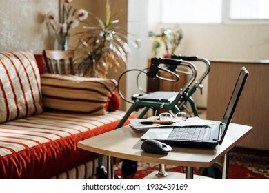 Disability Support Pension Life Insurance, Disability Medical Insurance Policy For Seniors. Laptop, Glasses And Documents On The Background Of Rollator Mobility Walker For Seniors. Selective Focus