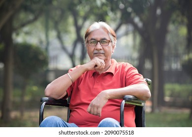 Disable senior man sitting in wheelchair at park

