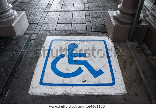 Disable\
sign at the train station. Sign of disable sign on the floor. Wheel\
chair symbol on the way to the train\
station.