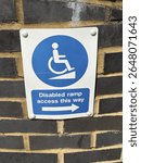Disabled access sign outside a modern church in North London pointing the way to the accesable ramp