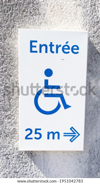 disabled accessible\
entree french text means entry sign posting with wheelchair\
handicap logo with arrow pointing side on wall entrance store\
access pictogram on street\
shop