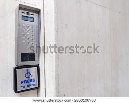 Disabled accessible push button buzzer for assistance sign at building entrance 