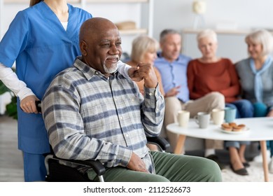 Disabled african american senior man in wheelchair holding nurse hand, looking at copy space and smiling, thanking for support, life in nursing home for elderly people concept - Powered by Shutterstock