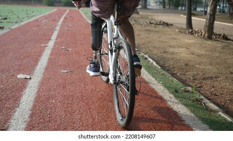 A disabled amputee cyclist riding bicycle with prosthetic leg - Powered by Shutterstock