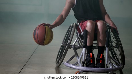 A disabled athlete in wheelchair playing basketball. Handicapped sportman