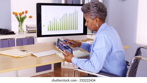 Disabled black businesswoman working at desk - Powered by Shutterstock