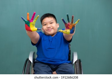 A Disabled Boy On Wheelchair Showing Hands With Colorful Colors And Smile Face.