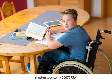 disabled boy in wheelchair doing homework