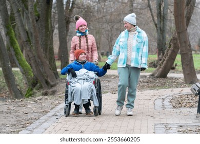 disabled boy, wheelchair, family walk in the park with a disabled child, mother with son and daughter, autumn, winter in Europe - Powered by Shutterstock