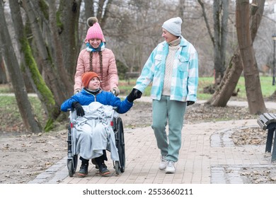 disabled boy, wheelchair, family walk in the park with a disabled child, mother with son and daughter, autumn, winter in Europe - Powered by Shutterstock