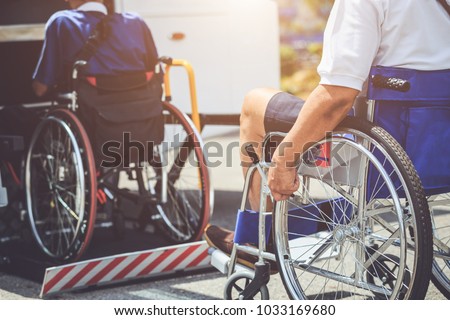 Disabled bus concept : Disabled people sitting on wheelchair and going to the public bus