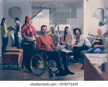 Disabled Businessman In A Wheelchair At Work In Modern Open Space Coworking Office With Team