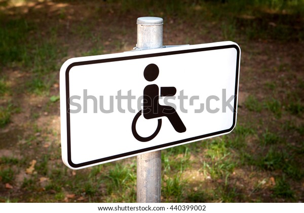 Disabled car parking sign in forest car\
parking in Lithuania.