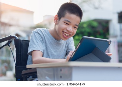 Disabled child on wheelchair happy time to use a tablet in the house, Study and Work at home for safety from covid 19, Life in the education age of special need kid, Happy disability boy concept. - Shutterstock ID 1704464179