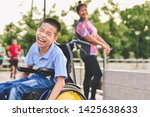 Disabled child on wheelchair is play and learn in the outdoor park like other people, Life in the education age of special children, Happy disability kid concept.