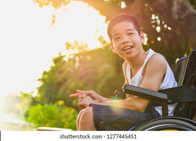 Disabled child on wheelchair is playing, learning and exercise in the outdoor city park like other people,Lifestyle of special child,Life in the education age of children,Happy disability kid concept.