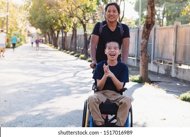 Disabled child on wheelchair is playing in the outdoor park like other people, He has a young aunt to take care of closely, Life in the education age of special children, Happy disability kid concept.