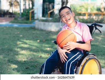 Disabled child on wheelchair is playing basketball on the lawn in front of the house like other people, Lifestyle of special child,Life in the education age of children, Happy disability kid concept.