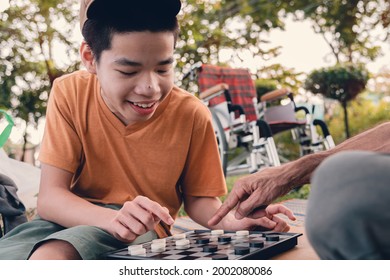 Disabled Child On Wheelchair Smiling Face As Happy With Parent In The Nature Outdoors Park, Lifestyle In The Education Age Of Special Need Kid, Happy Disability Teen And Diverse People Concept.