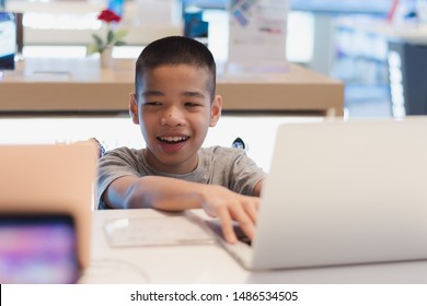 Disabled child on wheelchair trying to use a computer with excitement in an IT shop , Special children's lifestyle, Life in the education age of special need kids, Happy disability kid concept.